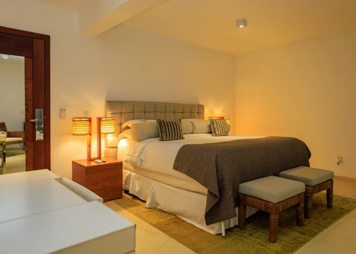 Quarto do Campo Bahia Hotel Villas Spa com cabeceira escura, criados-mudos em madeira e iluminação aconchegante