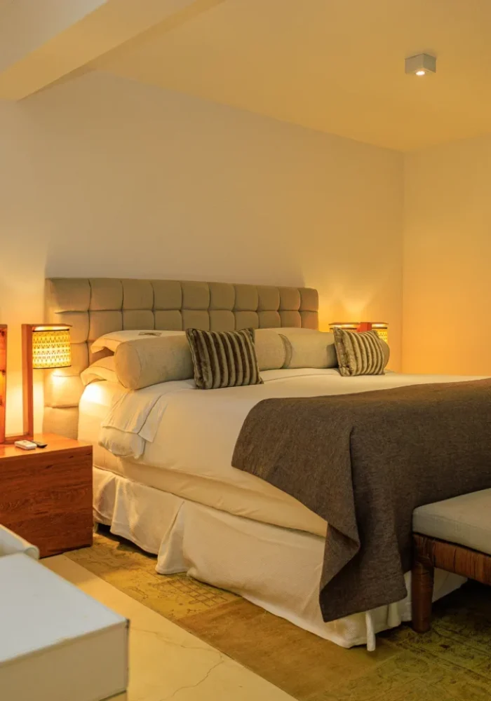 Quarto do Campo Bahia Hotel Villas Spa com cabeceira escura, criados-mudos em madeira e iluminação aconchegante