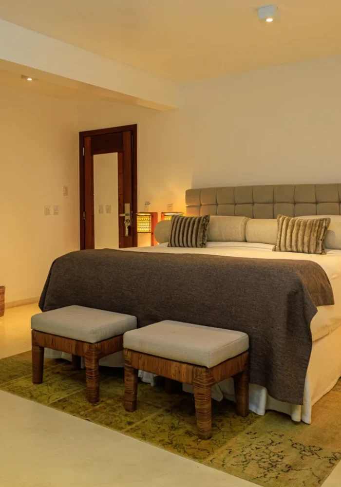 Quarto do Campo Bahia Hotel Villas Spa com cama de casal, cabeceira estofada e iluminação aconchegante