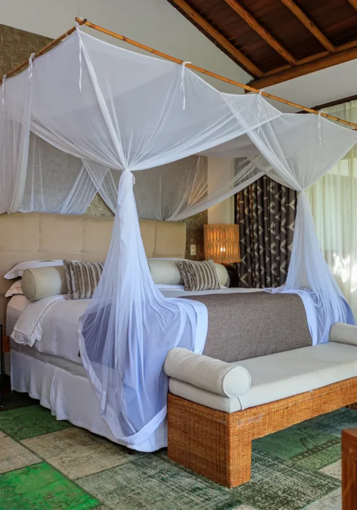 Quarto do Campo Bahia Hotel Villas Spa com dossel de tecido branco fino sobre a cama