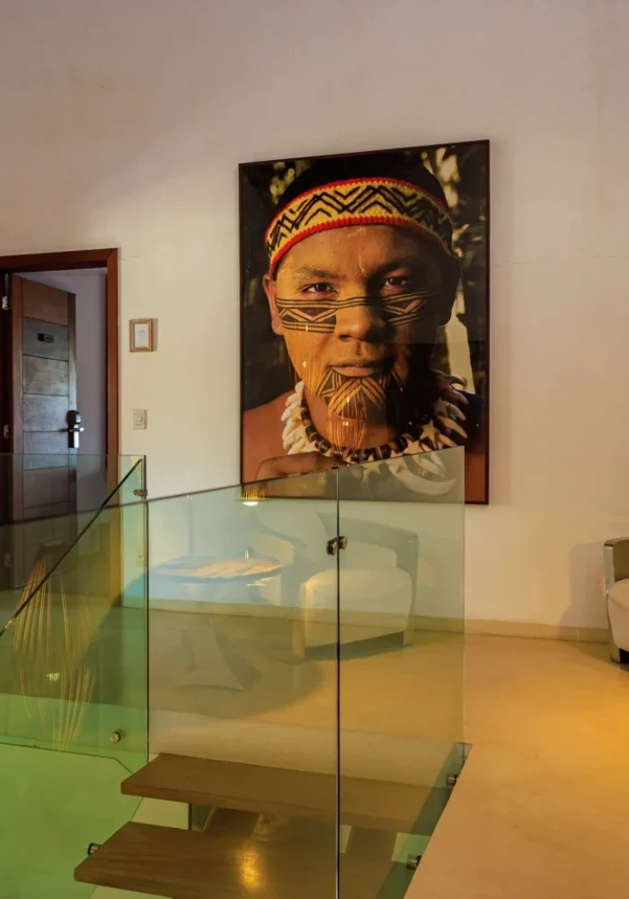Detalhe de janela com cortina listrada e vista para o jardim em acomodação do Campo Bahia Hotel Villas Spa