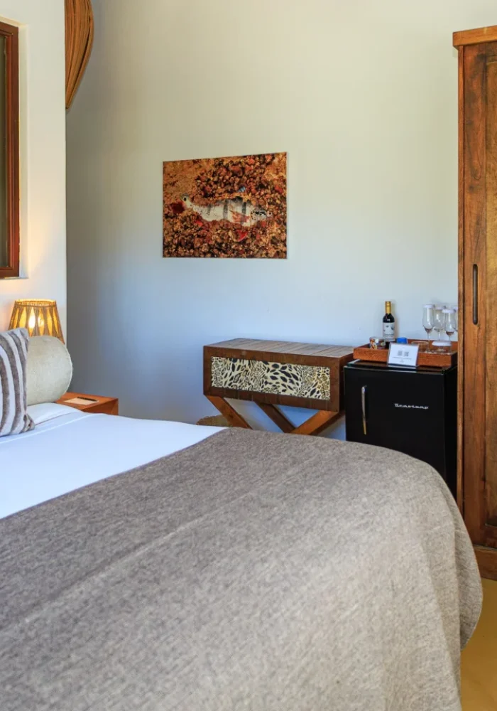 Quarto do Campo Bahia Hotel Villas Spa com cortinas estampadas e cama de casal